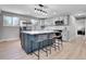 Modern kitchen featuring an island with seating, stainless steel appliances, and sleek countertops with luxury vinyl floors at 7054 Welch Ct, Arvada, CO 80004