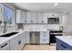 Kitchen featuring gray cabinetry, stainless steel appliances, and a white backsplash at 7054 Welch Ct, Arvada, CO 80004