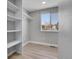 Spacious walk-in closet with built-in shelving and natural light with luxury vinyl flooring at 7054 Welch Ct, Arvada, CO 80004