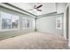 Spacious bedroom featuring a ceiling fan, neutral carpet, and three windows offering plenty of natural light at 10819 Mountshire Cir, Highlands Ranch, CO 80126