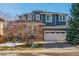 Charming two-story home features a two-car garage, red accents, and meticulous landscaping at 10819 Mountshire Cir, Highlands Ranch, CO 80126