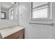 Bathroom vanity with a light countertop, wooden cabinets, mirror, and window at 264 S Newark Cir, Aurora, CO 80012