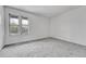 Bright bedroom featuring carpeted floors and two windows showcasing neighborhood views at 264 S Newark Cir, Aurora, CO 80012