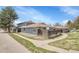 Exterior view of the blue-sided home surrounded by mature landscaping at 264 S Newark Cir, Aurora, CO 80012