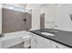 Bathroom features a modern vanity with a dark countertop and a shower-tub combination with tile surround at 8772 S Sicily Ct, Aurora, CO 80016