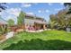 Expansive backyard with a hot tub, patio, and lush green lawn, ideal for outdoor enjoyment and entertaining at 5225 S Everett Ct, Littleton, CO 80123