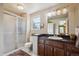 Bathroom featuring a dark wood vanity, glass shower door, and large vanity mirror at 5225 S Everett Ct, Littleton, CO 80123