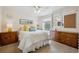 Bright bedroom with white bedding, wood dressers, and natural light from a window at 5225 S Everett Ct, Littleton, CO 80123