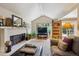 Cozy living room with a brick fireplace, vaulted ceilings, and access to the outdoors at 5225 S Everett Ct, Littleton, CO 80123