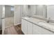 Bathroom featuring double vanity with granite countertop, white cabinets, and modern fixtures at 2174 Alyssa St, Fort Lupton, CO 80621