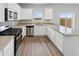 Bright kitchen features white cabinets, stainless steel appliances, granite countertops and a window overlooking the yard at 2174 Alyssa St, Fort Lupton, CO 80621