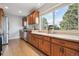 Spacious kitchen area with wooden cabinets, stainless steel appliances, and garden window at 4231 W Ponds Cir, Littleton, CO 80123