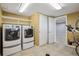 Laundry room offers tile floors, shelving, washer and dryer at 4231 W Ponds Cir, Littleton, CO 80123