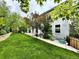 Side view of home showcasing lush green backyard with a stone pathway and garden at 10488 Bluffmont Dr, Lone Tree, CO 80124
