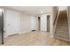 Partially finished basement with doors, a staircase and light laminate flooring at 10488 Bluffmont Dr, Lone Tree, CO 80124