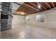 Unfinished basement with exposed ceilings, concrete flooring, and two windows at 10488 Bluffmont Dr, Lone Tree, CO 80124