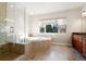 Bathroom featuring a shower, large tub, wood flooring and window bringing in natural light at 10488 Bluffmont Dr, Lone Tree, CO 80124