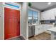 Inviting entryway with a vibrant red door opening to a bright kitchen with stainless steel appliances at 744 Grand Market Ave, Berthoud, CO 80513