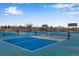 Outdoor pickleball courts with blue playing surfaces, nets, and surrounding fencing for recreational play at 744 Grand Market Ave, Berthoud, CO 80513