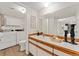 Bathroom boasts a well-lit vanity with a sink and a laundry area featuring a washer and dryer at 6388 Oak Ct # 104, Arvada, CO 80004
