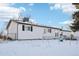 Back of house, white exterior, snowy yard at 10975 Birch Dr, Thornton, CO 80233