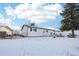 Back of house, white exterior, snowy yard at 10975 Birch Dr, Thornton, CO 80233