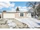 Brick ranch home with attached two-car garage and snowy front yard at 10975 Birch Dr, Thornton, CO 80233