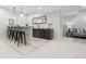 Finished basement bar area with modern pendants, seating for four, and a beverage center at 3041 S Bellaire S St, Denver, CO 80222