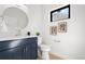 Contemporary bathroom with blue vanity, round mirror, and modern fixtures at 3041 S Bellaire S St, Denver, CO 80222