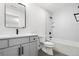 Modern bathroom featuring gray vanity, black fixtures, tub with shower, and tile surround at 3041 S Bellaire S St, Denver, CO 80222