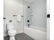 Modern bathroom featuring a white tub with grey tiling, black fixtures, and a white toilet at 3041 S Bellaire S St, Denver, CO 80222