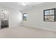 Bright bedroom featuring neutral carpet, two windows, and an ensuite bathroom at 3041 S Bellaire S St, Denver, CO 80222