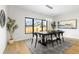 Bright dining room features a modern chandelier, hardwood floors, and a large window providing natural light and neighborhood views at 3041 S Bellaire S St, Denver, CO 80222