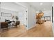 Inviting hallway featuring hardwood floors, an open staircase, and a glimpse into the bright, sunlit living spaces at 3041 S Bellaire S St, Denver, CO 80222