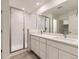 Modern bathroom featuring double sinks, quartz counters, and a glass-enclosed shower at 1286 S Algonquian St, Aurora, CO 80018