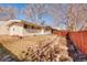 Spacious backyard features the exterior of the home and a red fence at 2370 S Meade St, Denver, CO 80219