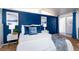 Comfortable bedroom featuring blue accent wall, modern art, stylish nightstands, and sliding glass door to the outside at 2370 S Meade St, Denver, CO 80219