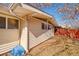 Side exterior featuring off-white siding, light fixtures and a fenced-in yard at 2370 S Meade St, Denver, CO 80219