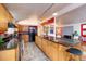 Open concept kitchen boasts an island, oak cabinets and black countertops at 2370 S Meade St, Denver, CO 80219