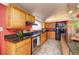 Bright kitchen featuring oak cabinets, stainless appliances, and black countertops at 2370 S Meade St, Denver, CO 80219