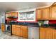 Spacious kitchen featuring oak cabinets, stainless appliances, and black countertops at 2370 S Meade St, Denver, CO 80219