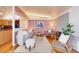 Bright living room with pink walls, hardwood floors, brick fireplace, and comfortable seating at 2370 S Meade St, Denver, CO 80219