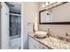Bathroom featuring granite countertop, bowl sink, and shower with stone-look walls at 480 S Marion Pkwy # 1601, Denver, CO 80209