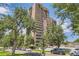 Stunning exterior view of a high-rise building featuring multiple balconies and surrounded by lush trees at 480 S Marion Pkwy # 1601, Denver, CO 80209