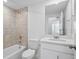 Bathroom with vanity and combined tub and shower, with beige tile surround at 16890 Black Rose Pl, Parker, CO 80134