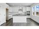 Modern kitchen features white cabinets, stainless steel appliances, and an island with a sink and countertop at 16890 Black Rose Pl, Parker, CO 80134