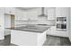 Bright kitchen features white cabinets, a gray countertop island, and stainless steel appliances at 16890 Black Rose Pl, Parker, CO 80134