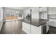 Bright kitchen features white cabinets, a gray countertop island, and a sliding door to the backyard at 16890 Black Rose Pl, Parker, CO 80134