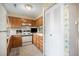 Wood kitchen cabinets, white appliances, and floral wallpaper at 3445 S Ammons St # 15-4, Lakewood, CO 80227