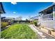 Lush backyard featuring a well-kept lawn, garden beds, and a charming patio area at 862 Centennial Way, Bennett, CO 80102